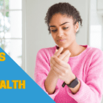 african american woman in pink sweater holding her hand in pain wearing a smart watch