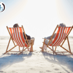 A couple sitting in chairs on a beach facing the ocean