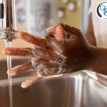 Person washing their hands at a sink with soap