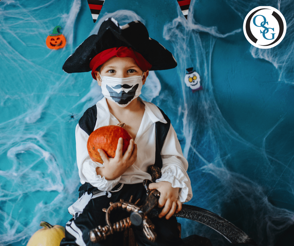 Young boy dressed as a pirate for Halloween and wearing a face mask
