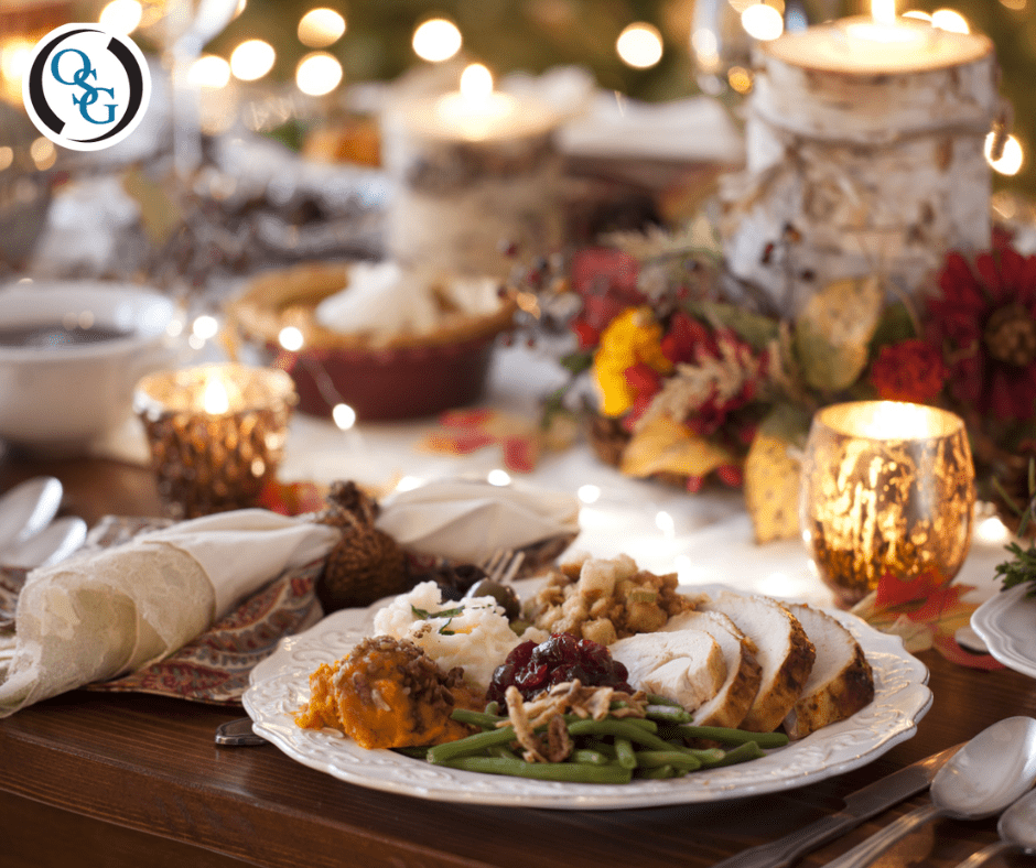 A close up of a plate filled with Thanksgiving foods on a decorated table