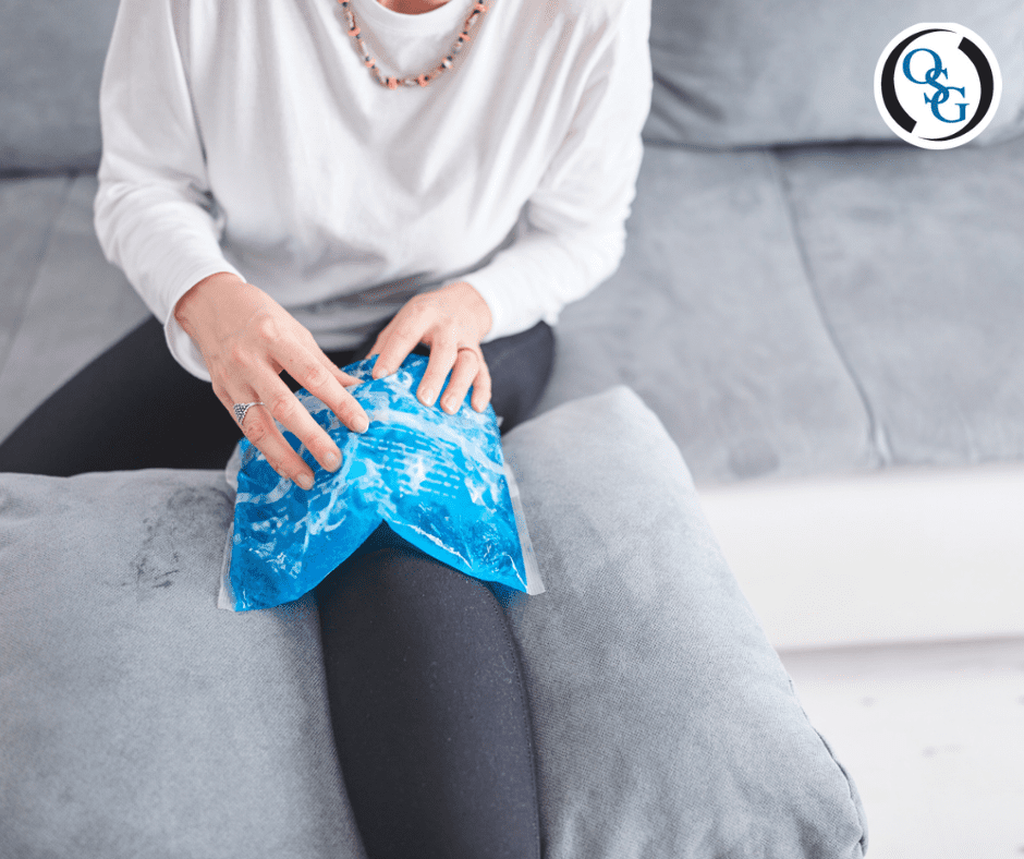 A woman in pain with an ice compress on her knee