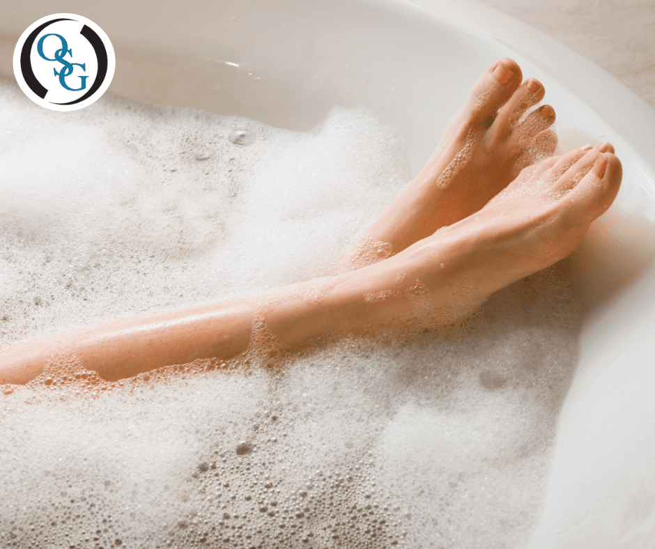 A woman's feet relaxed in a bathtub with soap