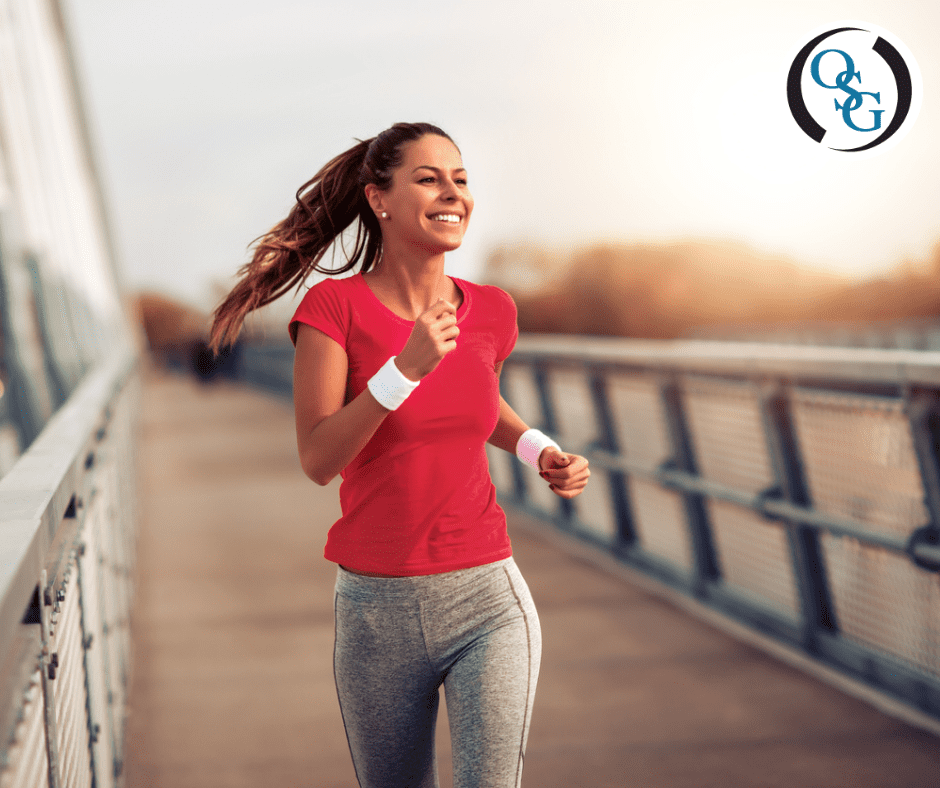 Young woman smiling and jogging across a bridge