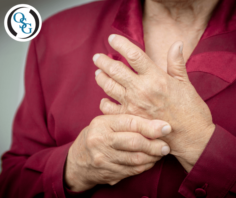 A woman grasping at her hands with rheumatoid arthritis