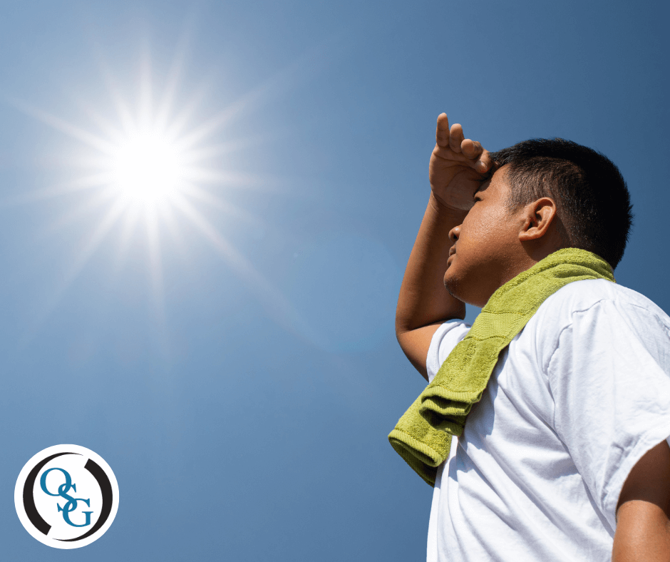 A man looking up at the sun on a hot day