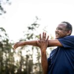 Senior man stretching in a park