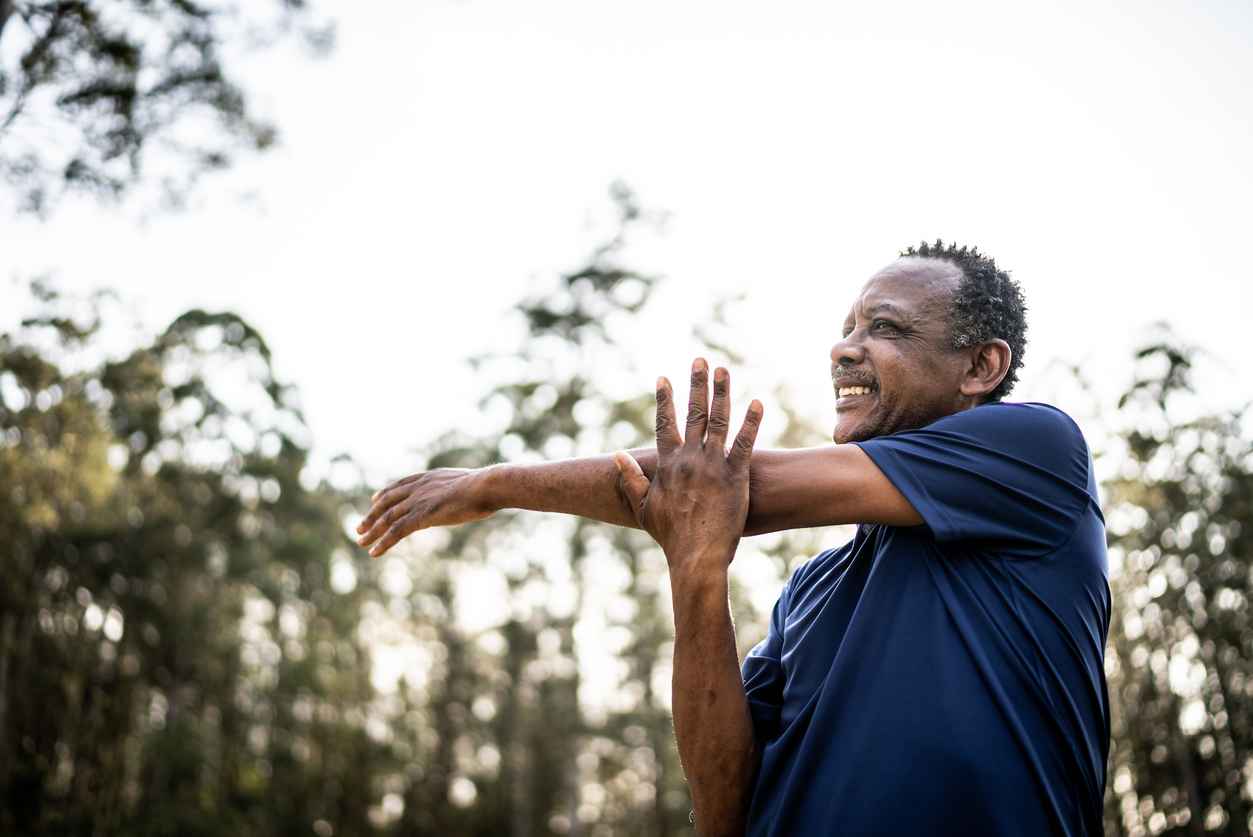 Senior man stretching in a park