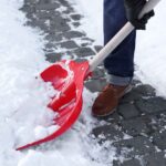 Man removing snow with shovel outdoors, closeup