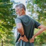 Senior men outdoors with back pain