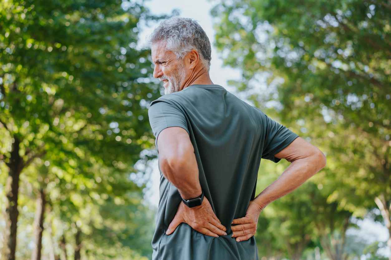 Senior men outdoors with back pain