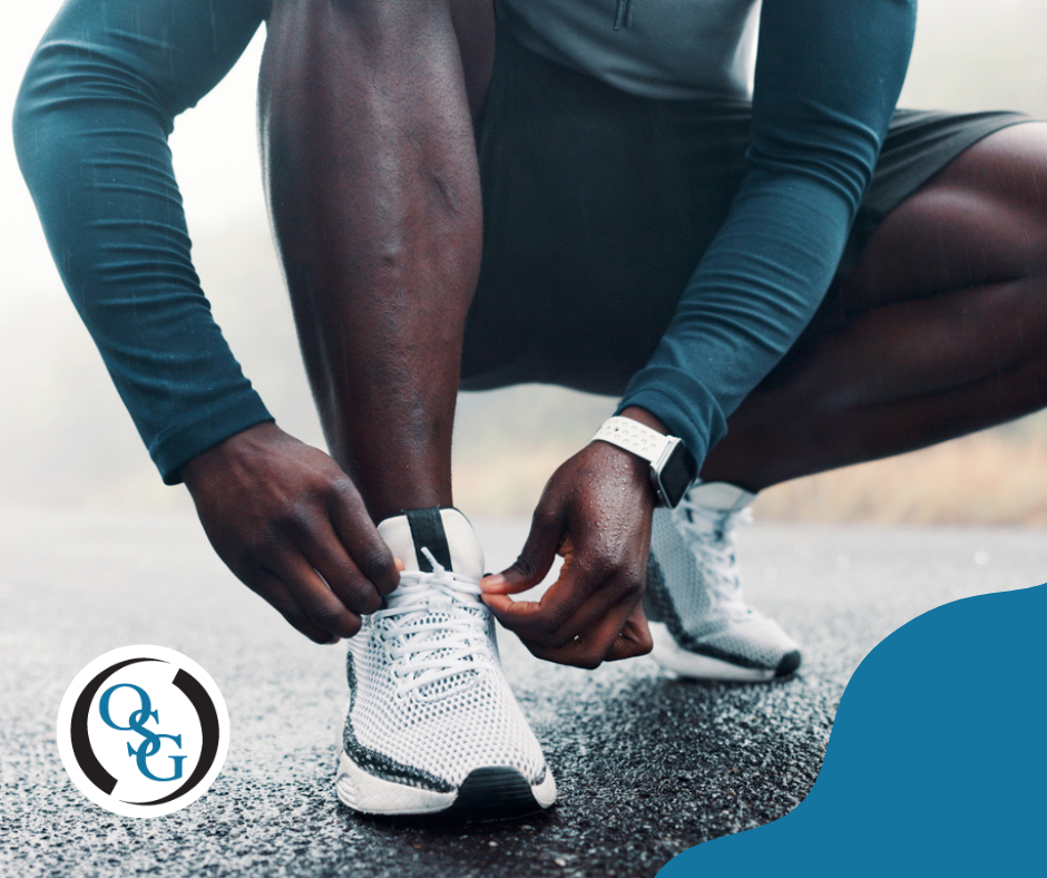A runner bending down to tie his sneaker